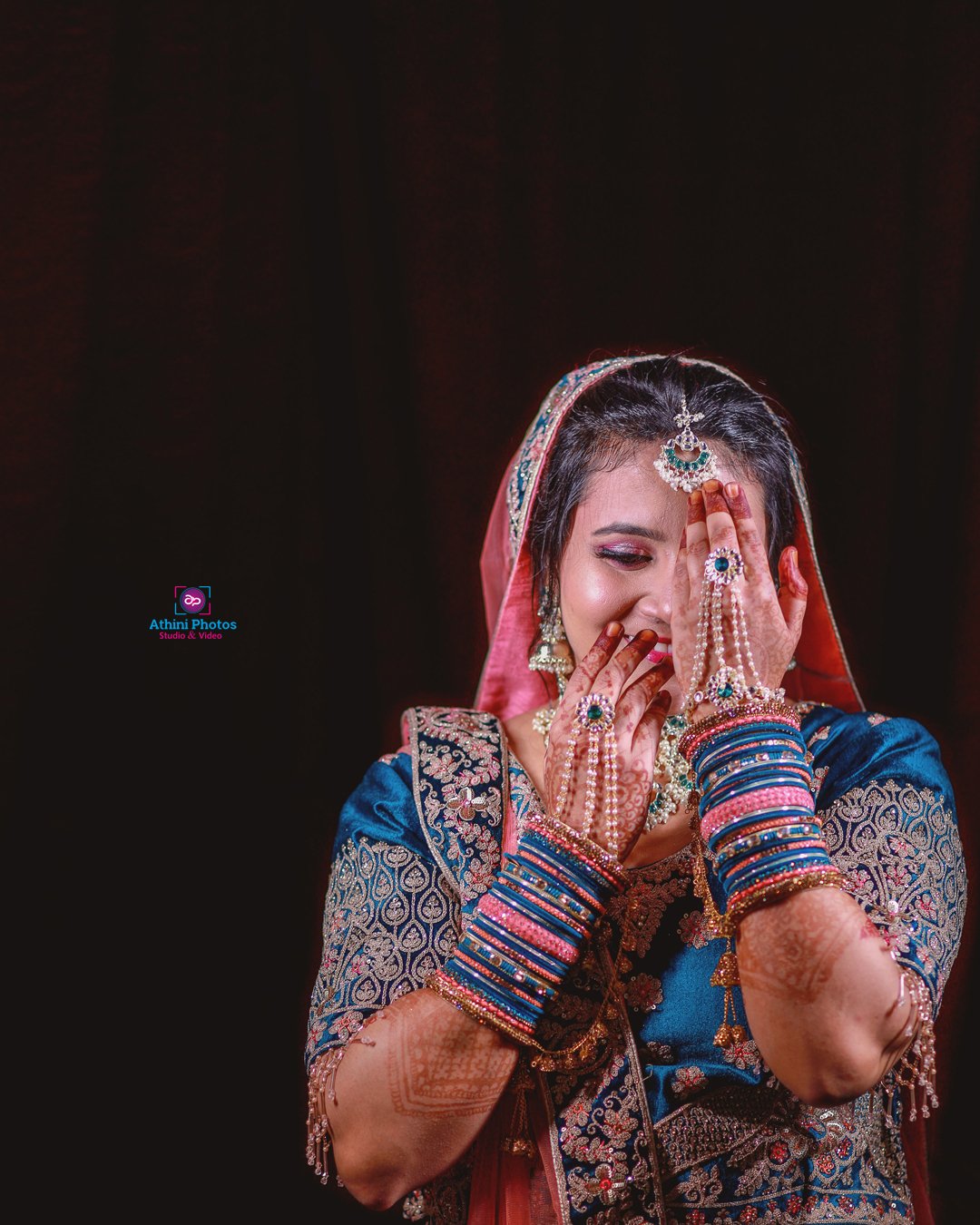 Indian Muslim bride in traditional wedding attire, surrounded by vibrant colors and intricate decorations.
