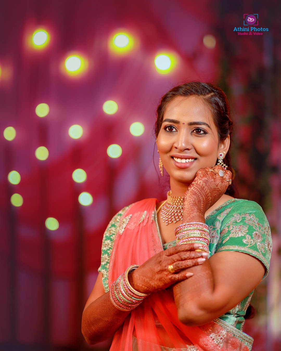 A stunning Indian bride in traditional sari, adorned with intricate jewelry and henna designs.