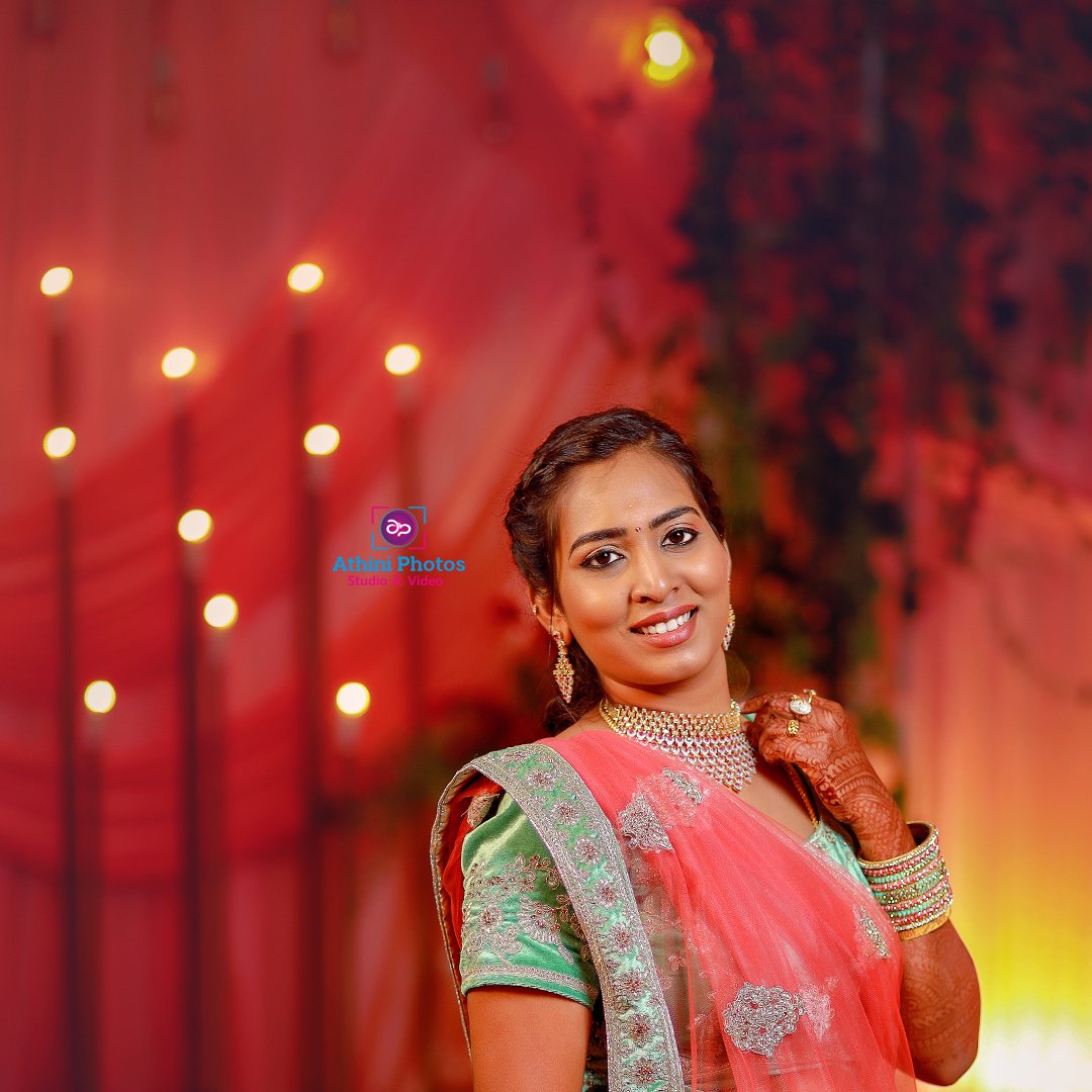 Indian bride in pink sari, adorned with traditional jewelry, looking radiant on her wedding day.