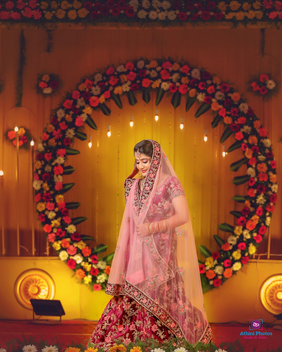 A Muslim bride in a pink lehenga and flower garland, traditional attire for a Muslim wedding.