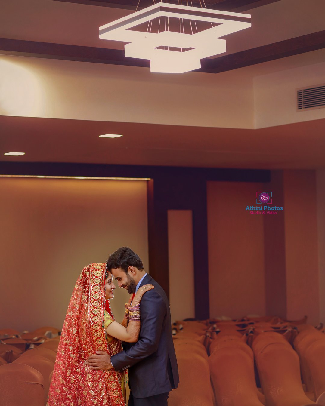 A Muslim couple in traditional Indian attire, standing in a spacious room during their wedding ceremony.