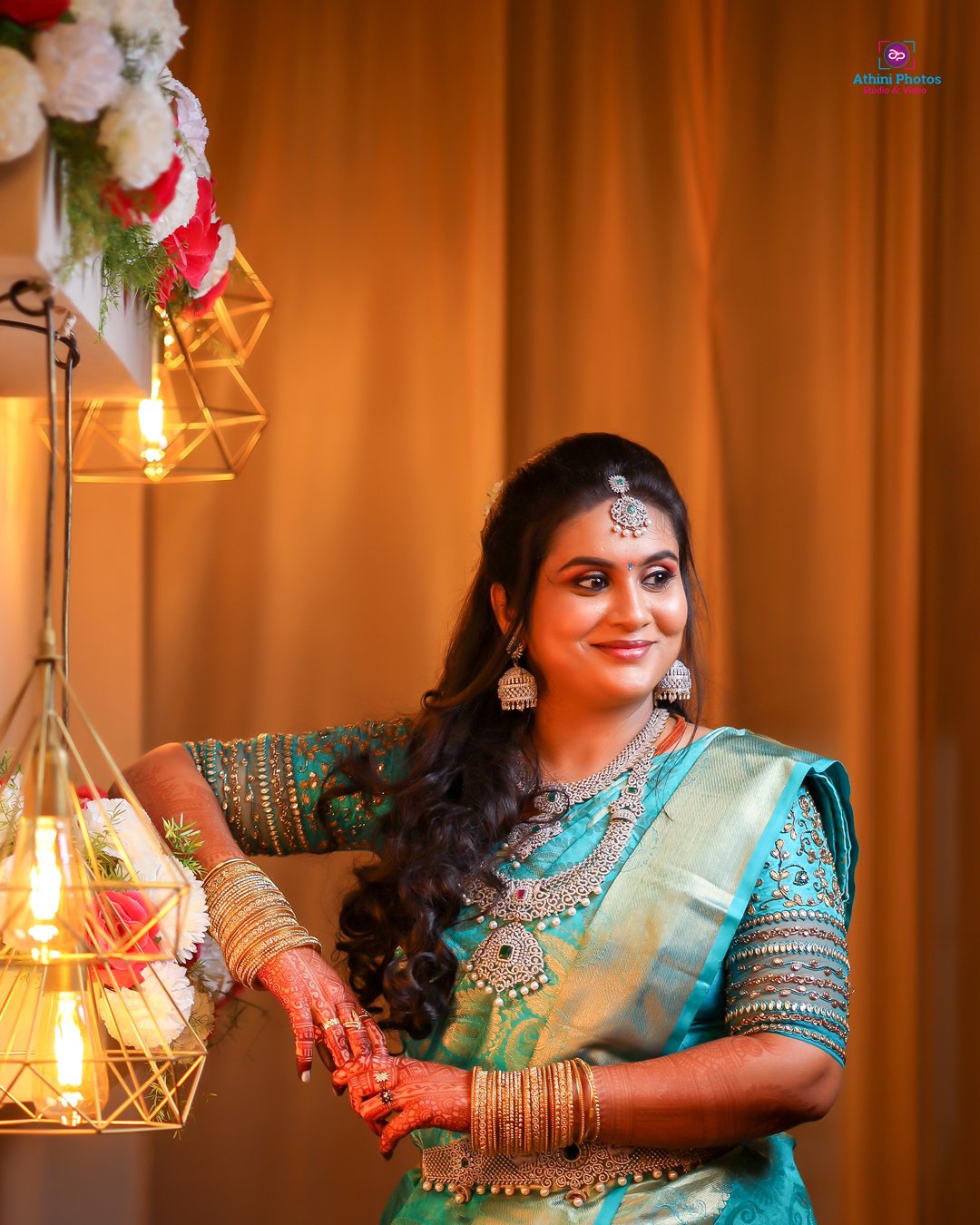 A stunning Indian bride in a blue sari posing for her wedding photoshoot.