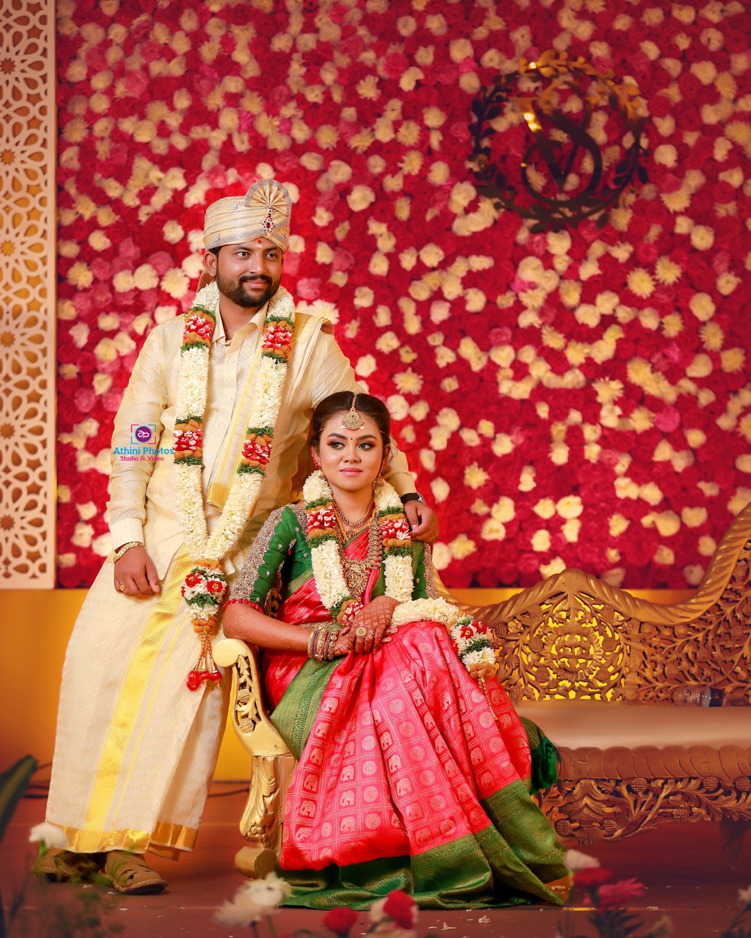 A man and woman in colorful traditional Indian attire, smiling and standing together at a cultural event.